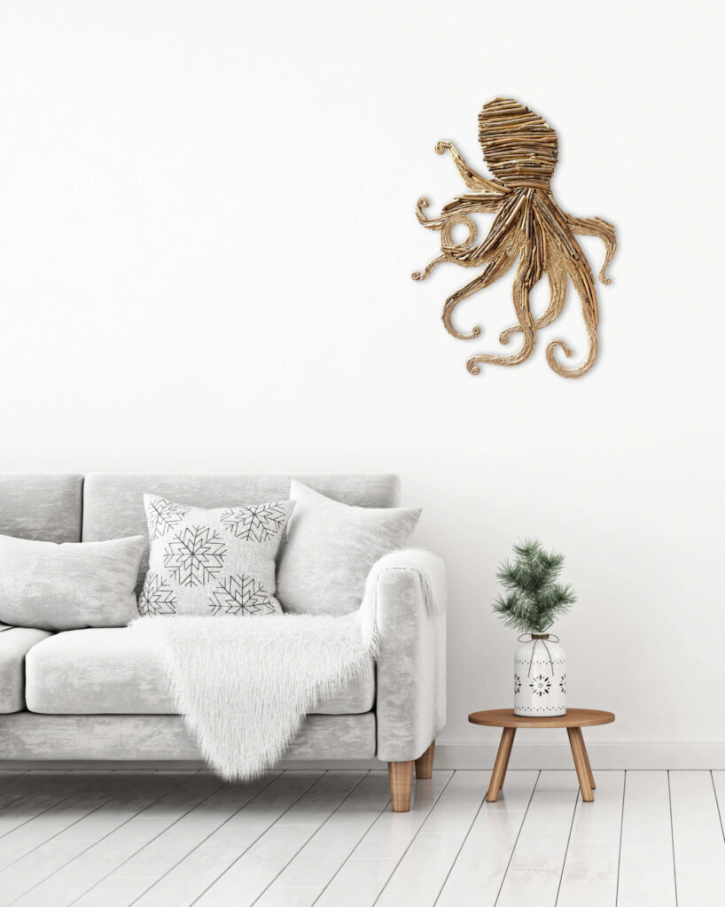 Silhouette de pieuvre en bois flotté accrochée au mur au dessus d'une table basse et d'un canapé cosy blanc